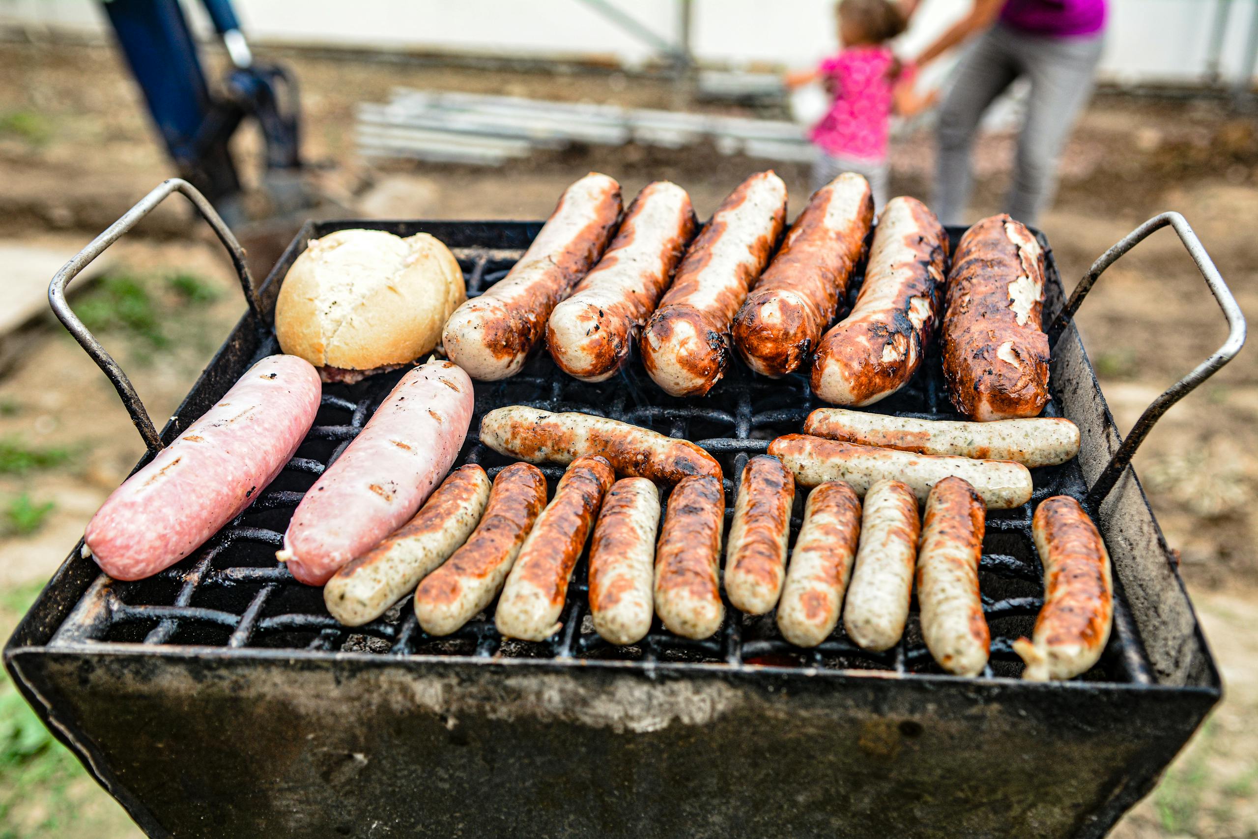 Delicious variety of grilled sausages on a barbecue, perfect for outdoor cookouts.